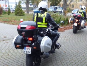 dwaj policjanci w kaskach jadą policyjnymi motocyklami