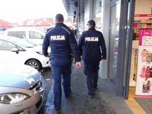 wzdłuż pasażu handlowego idą dwaj umundurowani policjanci