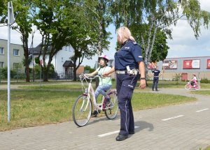 na zdjęciach znajdują się egzaminowane dzieci na rowerach i policjanci