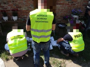 POLICJANCI W KAMIZELKACH ODBLASKOWYCH SPRAWDZAJĄ DEMONTOWANE POJAZDY