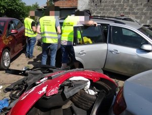 POLICJANCI W KAMIZELKACH ODBLASKOWYCH SPRAWDZAJĄ DEMONTOWANE POJAZDY