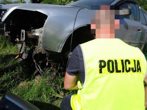 POLICJANCI W KAMIZELKACH ODBLASKOWYCH SPRAWDZAJĄ DEMONTOWANE POJAZDY
