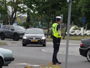 na rondzie w Łebie policjant ruchu drogowego kieruje ruchem pojazdów