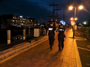 porą nocną dwaj policjanci służby prewencyjnej patrolują teren kanału portowego w Łebie