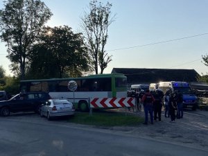 postój autokaru przewożącego kibiców. Przy autokarze znajdują się oznakowane i nieoznakowane radiowozy policyjne oraz policjanci oddziałów prewencji w strojach ochronnych oraz służby kryminalnej w kamizelkach taktycznych