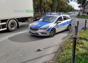 miejsce wypadku drogowego. Na skrzyżowaniu ulic stoi policyjny radiowóz. Przed nim na jezdni leży kobiecy but