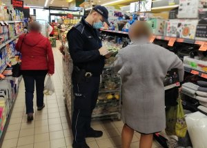 w sklepie umundurowany policjant legitymuje kobietę