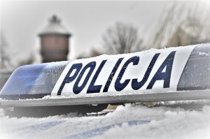 napis policja na ośnieżonej belce na dachu radiowozu