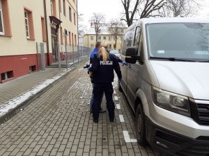 policjanci wprowadzają do radiowozu zatrzymanego mężczyznę