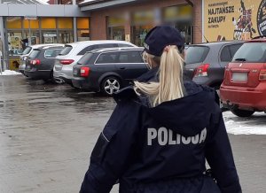 umundurowana policjantka idzie w stronę wejścia do dyskontu