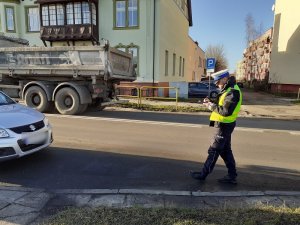 policjant ruchu drogowego dokonuje oględzin samochodu suzuki, który uczestniczył w wypadku