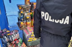 przed stoiskiem handlowym z fajerwerkami stoi umundurowany policjant