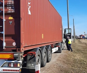 dwaj policjanci ruchu drogowego przeprowadzają kontrolę pojazdu ciężarowego