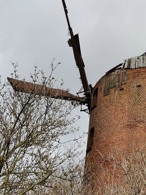 fragment zabytkowego wiatraka z widocznymi uszkodzeniami śmigła