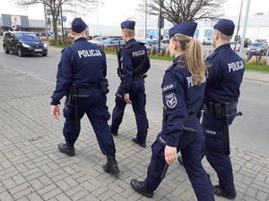 czworo umundurowanych policjantów idzie chodnikem