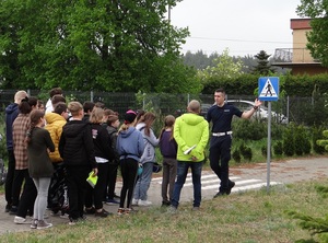 na terenie miasteczka rowerowego lęborskiej komendy Policji znajduje się grupa młodzieży, która słucha policjanta stojącego przy znaku drogowym przejście dla pieszych