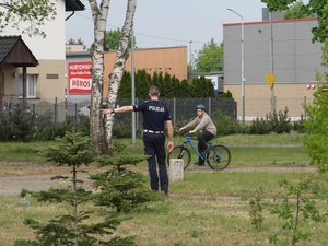 na terenie miasteczka ruchu drogowego lęborskiej komendy Policji policjant kontroluje sposób jazdy chłopca poruszającego się rowerem