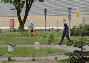 na terenie miasteczka ruchu drogowego lęborskiej komendy Policji policjant kontroluje sposób jazdy dziewczynki poruszającej się rowerem