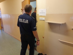 policjant służby dyżurnej zamyka drzwi celi w której znajduje się zatrzymany