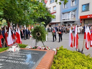 do pomnika Pocztowców Gdańskich podchodzą z kwaitami komendant lęborskiej policji z komendantem straży pożarnej