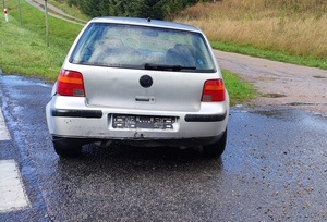 na poboczu drogi stoi srebrny vw golf. Z tyłu ma wgniecioną karoserię