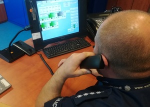 dyżurny policji na stanowisku kierowania rozmawia przez telefon