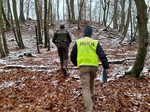 strażnik leśny i policjant idą wzniesieniem w kierunku grodziska