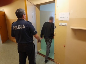 do celi wchodzi mężczyzna. Za nim stoi policjant służby dyżurnej