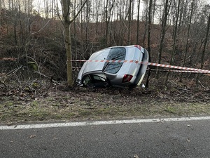 przy drodze w rowie leży przewrócony na bok srebrny renault megane. Miejsce zdarzenia jest odgrodzone taśmą