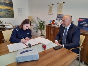 przy biurku w obecności wójta gminy Wicko zastępczyni Komendanta Powiatowego Policji w Lęborku podpisuje dokumenty przekazania alkotestów.