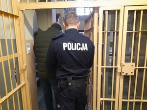 policjant wyprowadza zza krat mężczyznę