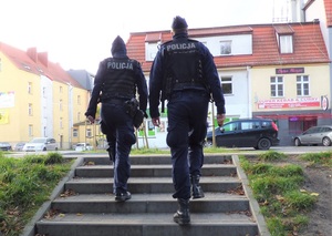 w parku po schodach idą dwaj policjanci służby patrolowej