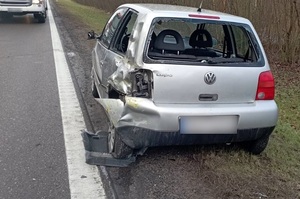 na poboczu znajduje się srebrny vw lupo z uszkodzonym tyłem i lewym bokiem oraz wybitą tylną szybą