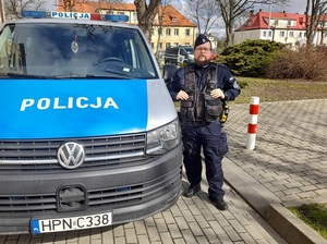 przy radiowozie stoi policjant służby prewencyjnej