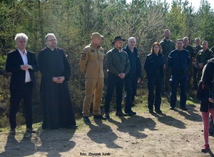 na drodze leśnej stoją w rzędzie przedstawiciele władz samorządowych, duchowieństwa, straży pożarnej, policji