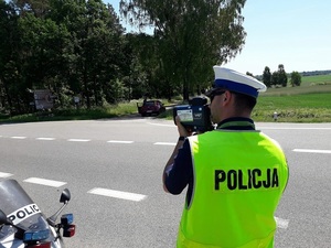 na drodze policjant ruchu drogowego mierzy prędkość za pomocą ręcznego miernika