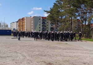 policjanci prowadzą grupę kibiców na trybuny