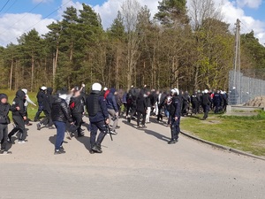 policjanci prowadzą grupę kibiców w stronę trybun