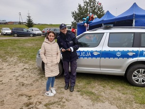 na festynie przy radiowozie stoją obok siebie policjantka i nastolatka