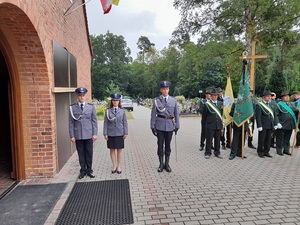 przed wejściem do kościoła stoją w rzędzie: policjantka i dwaj policjanci oraz członkowie koła łowieckiego w mundurach