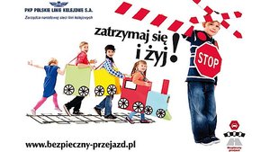 grafika przedstawiająca dzieci na torach kolejowych, przebrane za pociąg. Obok stoi chłopiec ze znakiem STOP oraz krzyżem św. Andrzeja