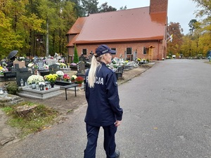 policjantka idzie cmentarną alejką