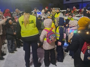 na placu znajduje się policjantka ruchu drogowego w otoczeniu dzieci