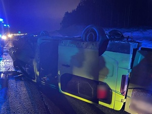 pora wieczorowa. Miejsce zdarzenia drogowego. Na jezdni leży przewrócony na dach pojazd typu bus