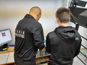 technik kryminalistyki zdejmuje odciski palców mężczyzny