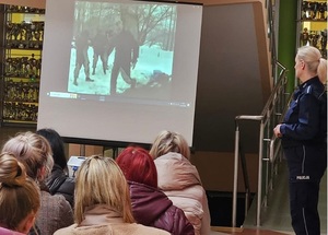 w sali gimnastycznej szkoły policjantka prowadzi prelekcję wśród zgromadzonych rodziców. Na ekranie rzutnika wyświetla się film