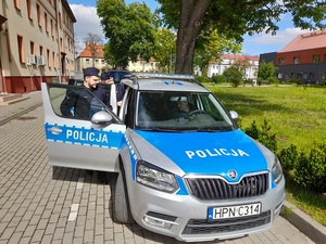 policjanci wsiadają do oznakowanego radiowozu