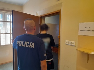 do celi wchodzi mężczyzna. Za nim stoi policjant służby dyżurnej