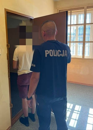 do celi wchodzi mężczyzna. Za nim stoi policjant służby dyżurnej