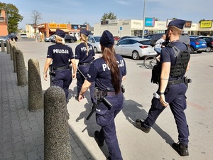 czworo policjantów - policjant i trzy kursantki przechodzą przez parking